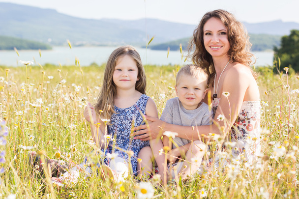 Familie: Mutter, Mädchen und Junge im Kamillenfeld - Foto, Bild