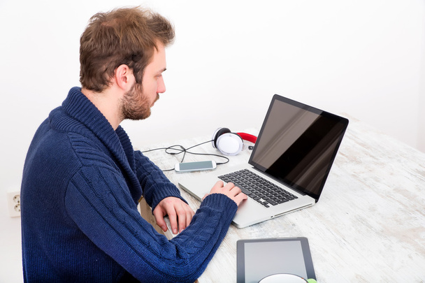 Молодой человек использует свой ноутбук дома
 - Фото, изображение