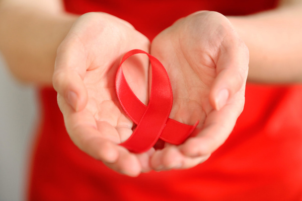 Woman holding red ribbon.  - Zdjęcie, obraz