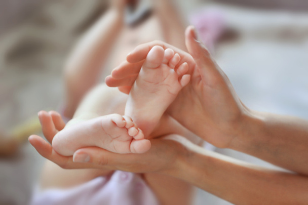 Woman holding small baby feet - Foto, imagen