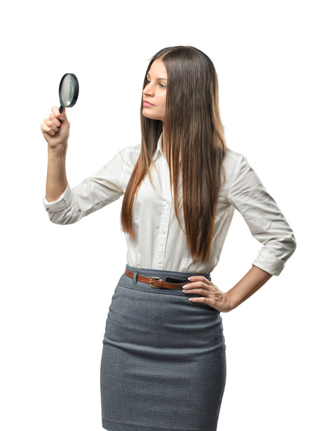 Cutout businesswoman studies something through a magnifier - Фото, изображение