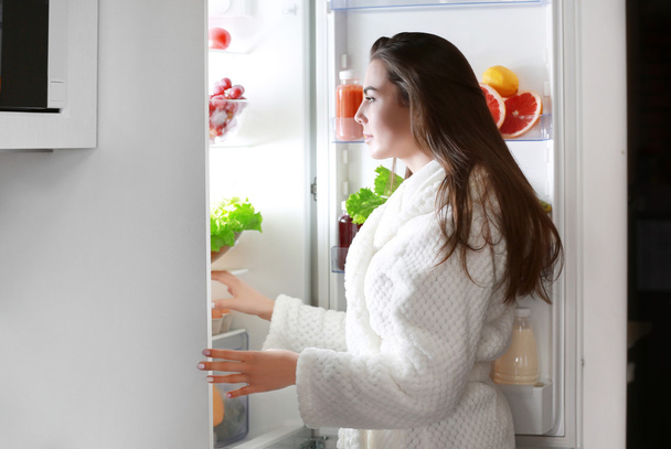 woman looking into fridge at night - Photo, image
