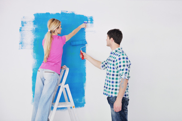 Happy couple paint wall at new home - Foto, Bild