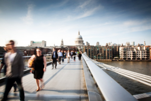 wazig achtergrond van menigte van mensen op millennium brug en st pauls kathedraal op de achtergrond, london - Foto, afbeelding