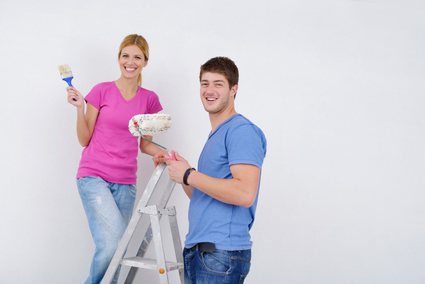 Happy couple paint wall at new home - Foto, imagen