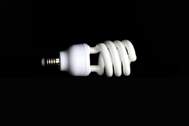 Ampoule fluorescente à économie d'énergie sur fond noir
 - Photo, image