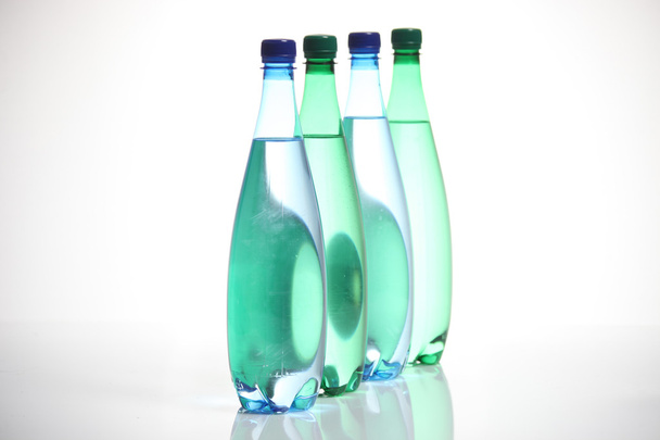 Four glass bottles standing in a row. - Photo, image