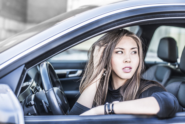 brunette woman with hand on hair  in car - 写真・画像