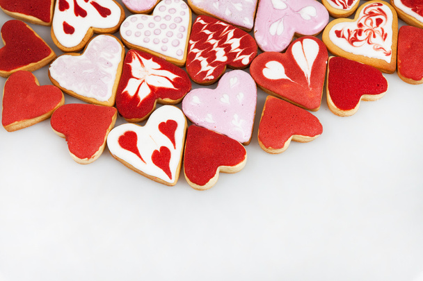 バレンタインデーのクッキー。ハートのクッキーをバレンタインの日に。赤とピンクのハート型のクッキー。バレンタインデーの背景。クッキー ハートのロマンチックなシームレス パターン. - 写真・画像