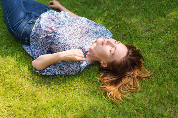 Szczęśliwe kobiety leżącej na zielonej trawie - Zdjęcie, obraz