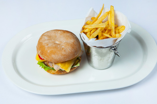Verse hamburger in plaat met groenten en frietjes. Grote hamburger. Ingrediënten voor hamburgers. Bovenaanzicht - Foto, afbeelding