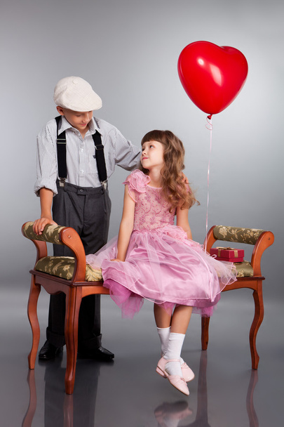 The boy gives a red balloon to the girl - Fotoğraf, Görsel