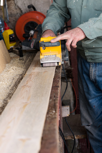carpenter works with belt sander in carpentry - Photo, Image