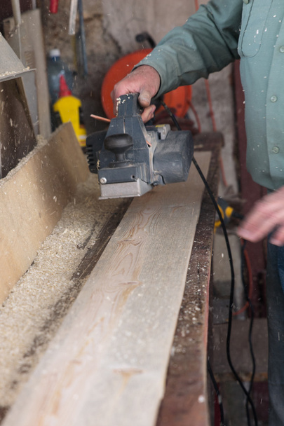 carpenter works with belt sander in carpentry - Photo, Image
