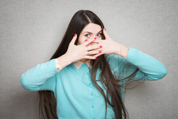 girl covers mouth with hands - Foto, Bild
