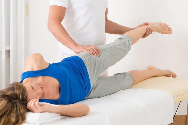 Male Therapist Giving Leg Massage To Woman - Photo, image