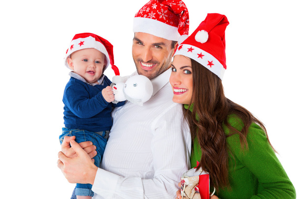 Счастливые родители с маленьким мальчиком в шляпах Санты
 - Фото, изображение