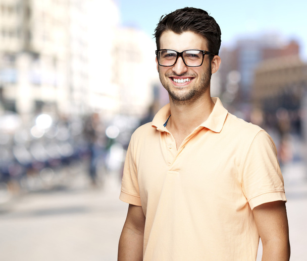 portret młodego mężczyzny opowiadająca uśmiechający się na zatłoczonej ulicy - Zdjęcie, obraz