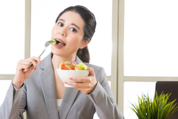 Giovane donna d'affari asiatica godendo di un'insalata sana
 - Foto, immagini