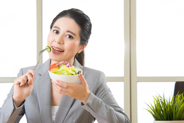 Молодая азиатская бизнесвумен наслаждается здоровым салатом
 - Фото, изображение