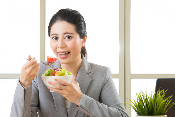 Young asian businesswoman enjoying a healthy salad - Fotó, kép