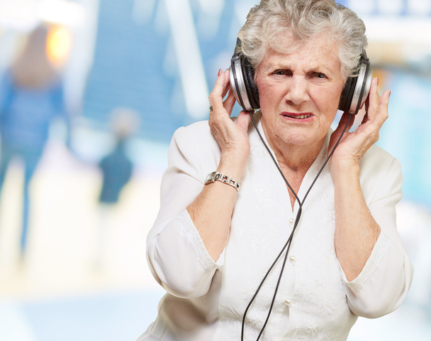 πορτρέτο της ηλικιωμένης γυναίκας που ακούει μουσική σε εσωτερικούς χώρους - Φωτογραφία, εικόνα