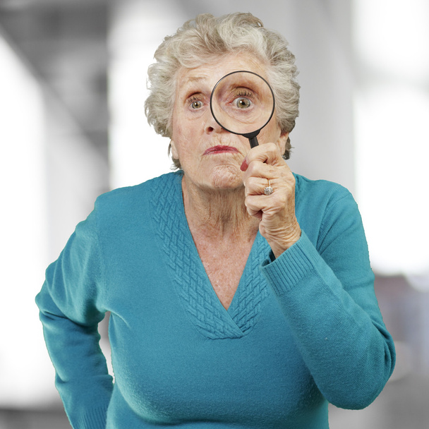 Portrait de femme âgée regardant à travers une loupe, ind
 - Photo, image