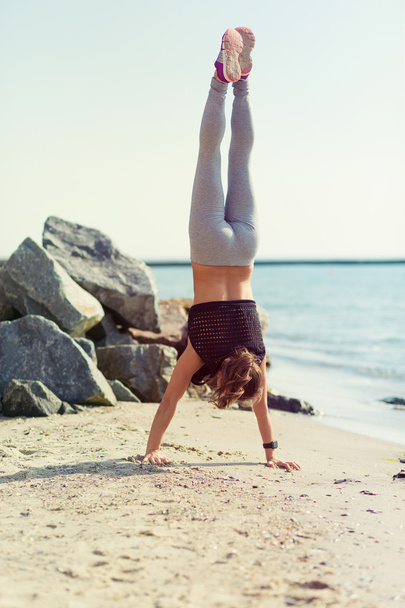 Woman practicing yoga at the beach - Фото, зображення