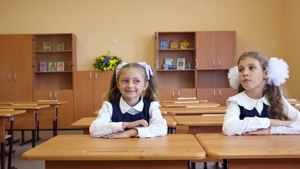 Duas meninas sentam-se nas secretárias da escola
 - Filmagem, Vídeo