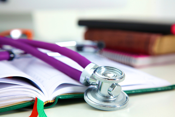 Stethoscope lying on a table on an open book - Photo, Image