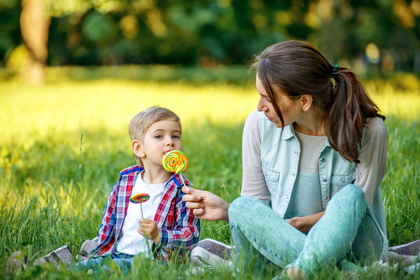 Mother with baby in the park eating sweets. - Foto, immagini