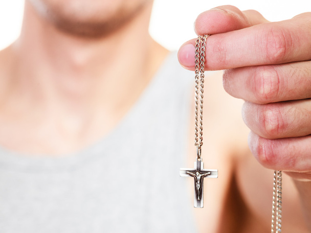 Man holding cross pendant. Catholic religion faith - Foto, afbeelding