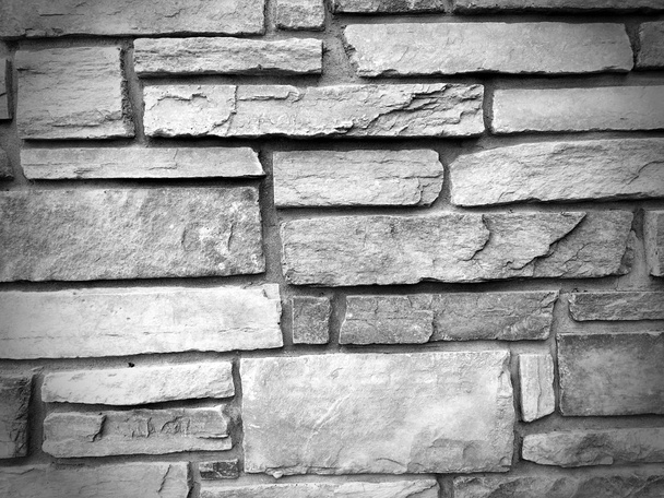 ongelijke gebarsten stenen muur textuur achtergrond in balck en wit - Foto, afbeelding