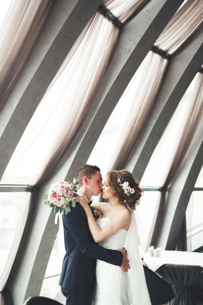 wedding couple is standing and kissing in hotel - Fotoğraf, Görsel