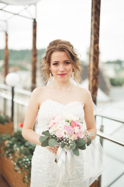 Bride holding big wedding bouquet on ceremony with perfect landscape - Foto, afbeelding