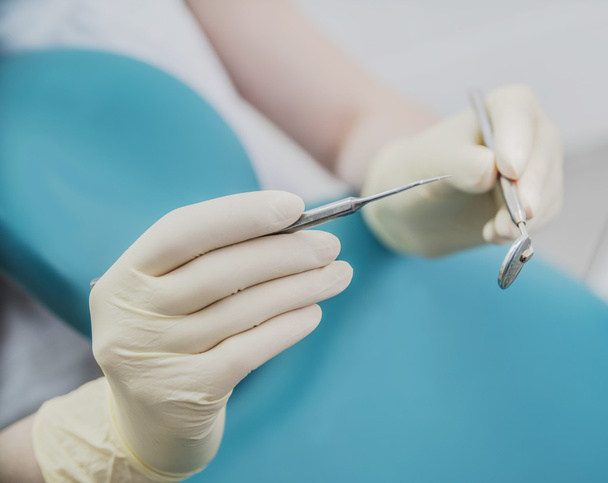 Doctor in de rubberen handschoenen houden tandheelkundige apparatuur - Foto, afbeelding