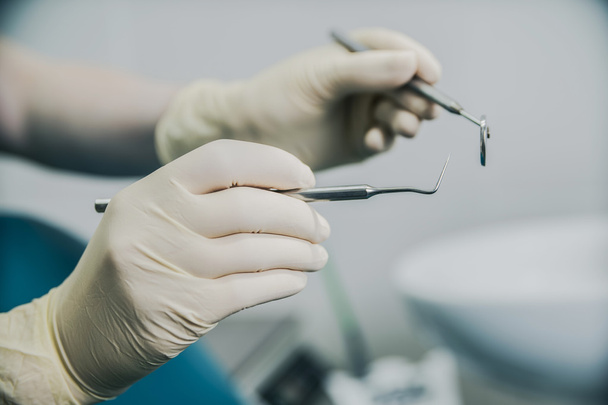lekarz w Rękawice gumowe, trzymając sprzęt dentystyczny - Zdjęcie, obraz