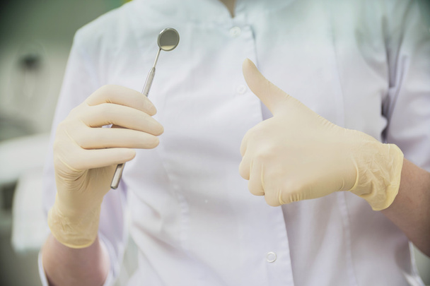 стоматолог в резиновых перчатках и с белым зеркалом во рту в больнице
 - Фото, изображение