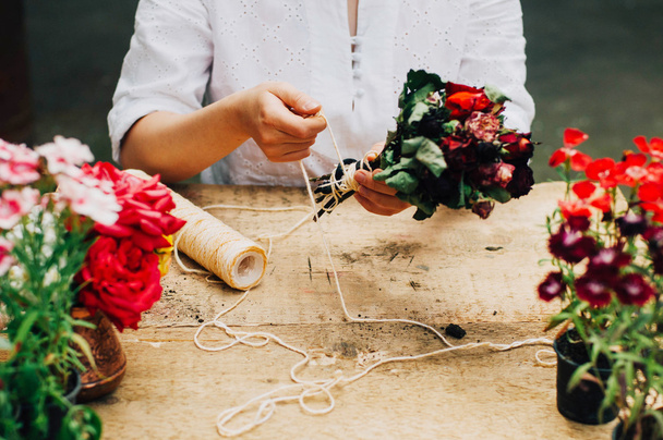 庭師テーブル素朴で園芸の仕事をしています。女性気 flowerscarnations の手のクローズ アップ庭で作業している。梨花の手。花とガーデン ツール. - 写真・画像