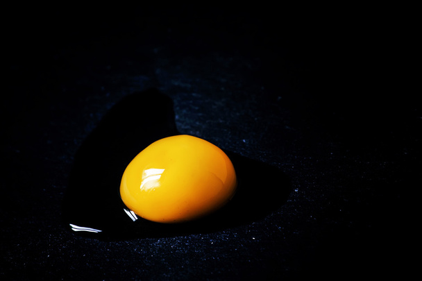 Egg yolk on a dark background - Foto, imagen