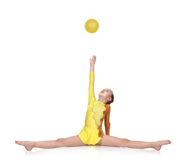 gymnast sitting on split with yellow ball - Foto, Imagem