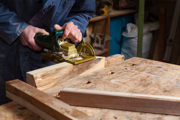 тесляр працюючи на дерев'яних дошках у своїй майстерні
 - Фото, зображення