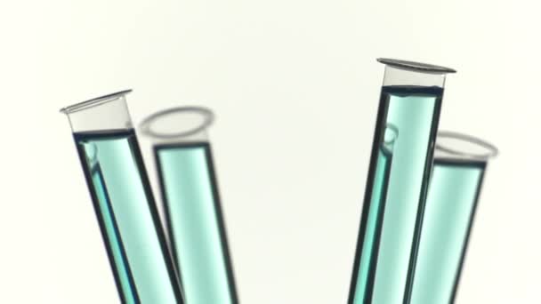 Reagenzglas mit blauer Flüssigkeit gefüllt, einen Tropfen Wasser gießen - Filmmaterial, Video