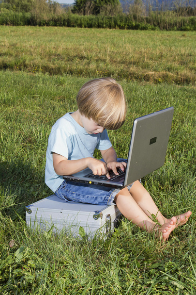 Молодий хлопчик друкує на ноутбуці
 - Фото, зображення