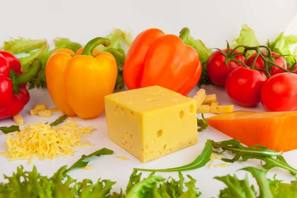 Pieces of cheeses, grated cheese, tomatoes, peppers and leaves of frillis and arugula - Фото, зображення