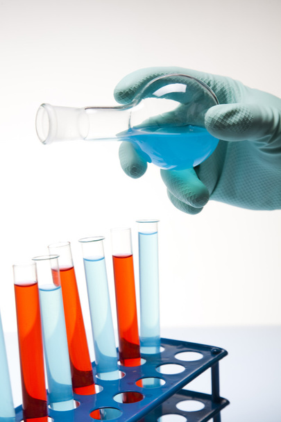Scientist working in a laboratory , glass containing liquid color - Foto, Bild