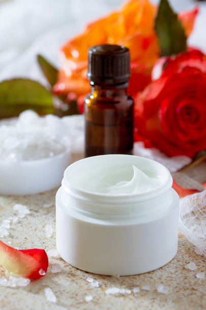 Crema viso con rose, flacone di olio essenziale di aromaterapia e
  - Foto, immagini
