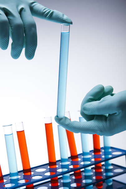 wetenschapper werken in een laboratorium, glas met vloeibare kleur - Foto, afbeelding