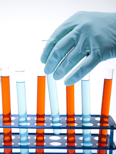 wetenschapper werken in een laboratorium, glas met vloeibare kleur - Foto, afbeelding