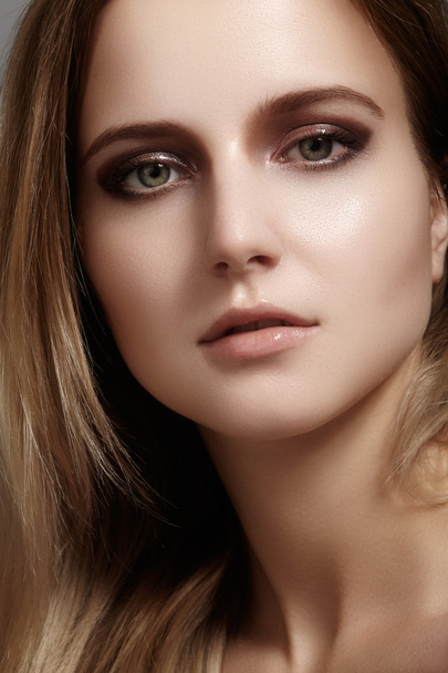 Beautiful young woman with gloss eyes and lips visage, dark blond color long hair. Beauty portrait with clean skin, glamour fashion makeup. Cosmetics, make up, hairstyle. Haircare - Foto, imagen